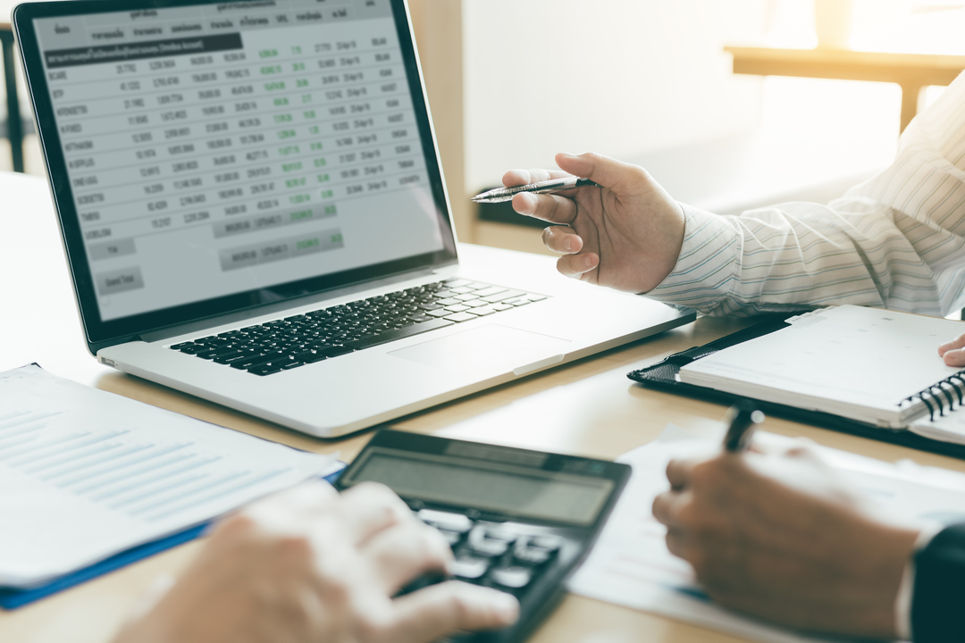 Profissional de contabilidade analisando relatórios e gráficos no computador