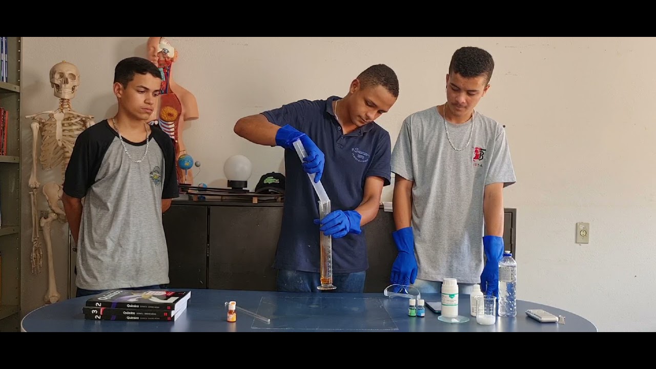 Professor conduzindo aula prática de Física em laboratório escolar, com interação com estudantes