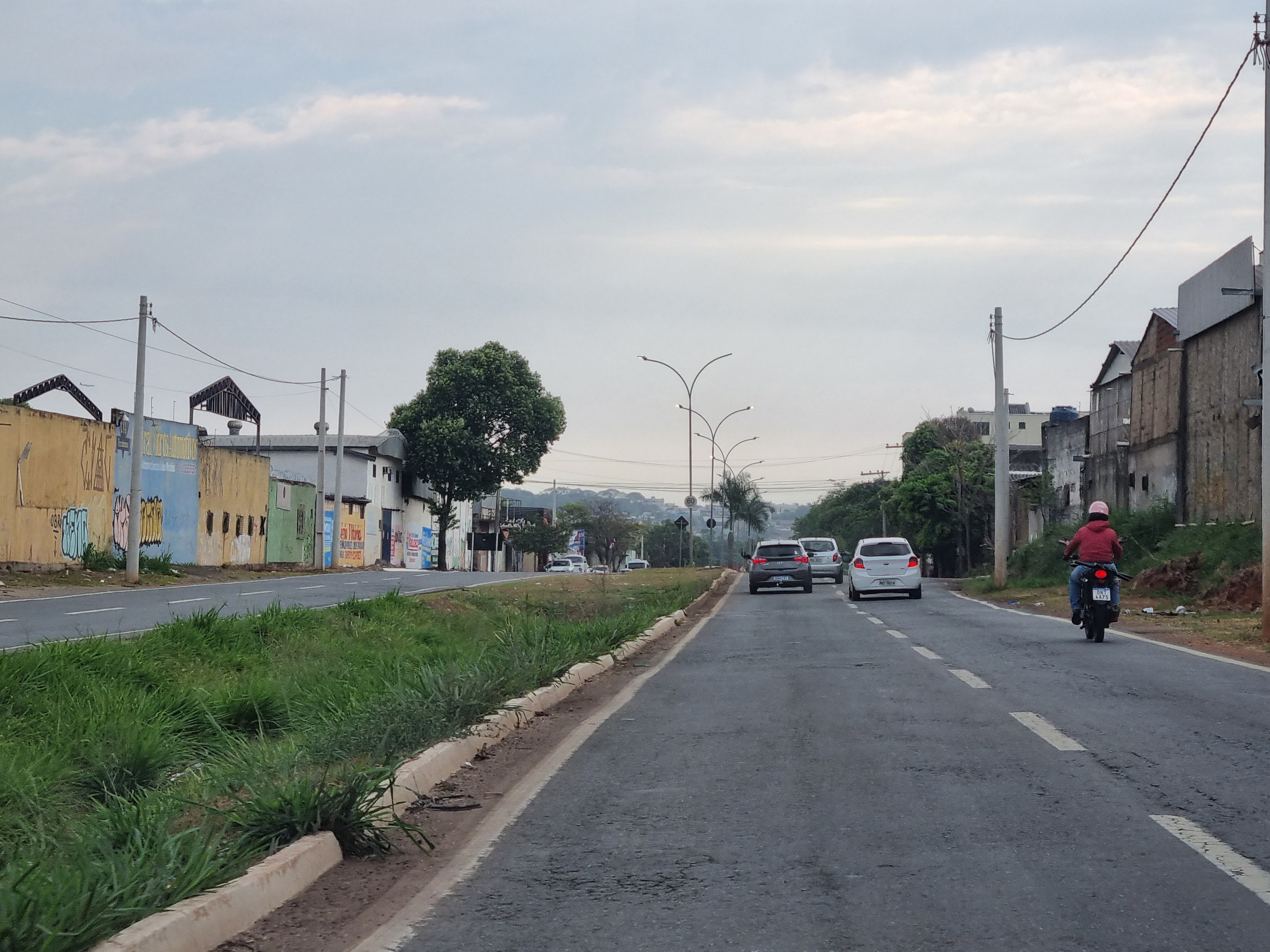 Vista urbana representativa de cidade do Centro-Oeste brasileiro, com pista dupla, comércios e céu nublado