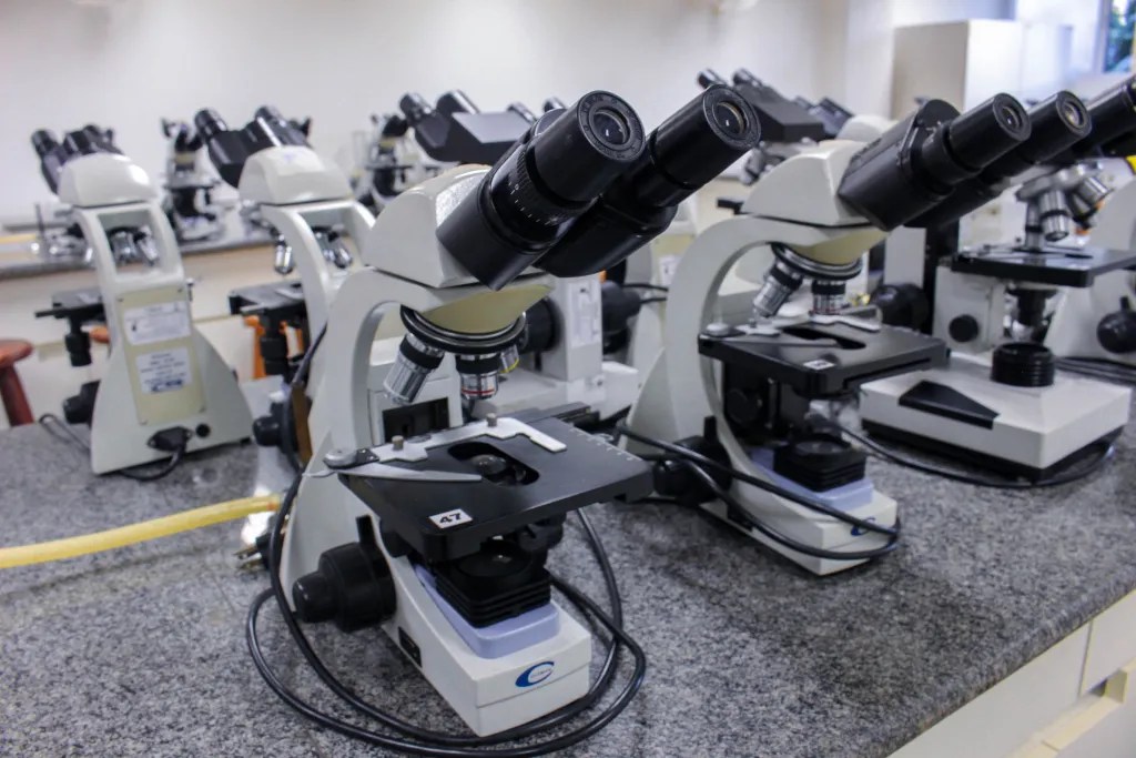 Laboratório moderno com microscópios e lâminas, representando ambiente de histopatologia