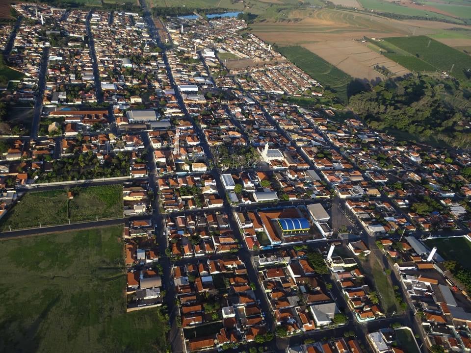 Vista aérea de Taiúva SP, com área urbana e praça central sob céu azul