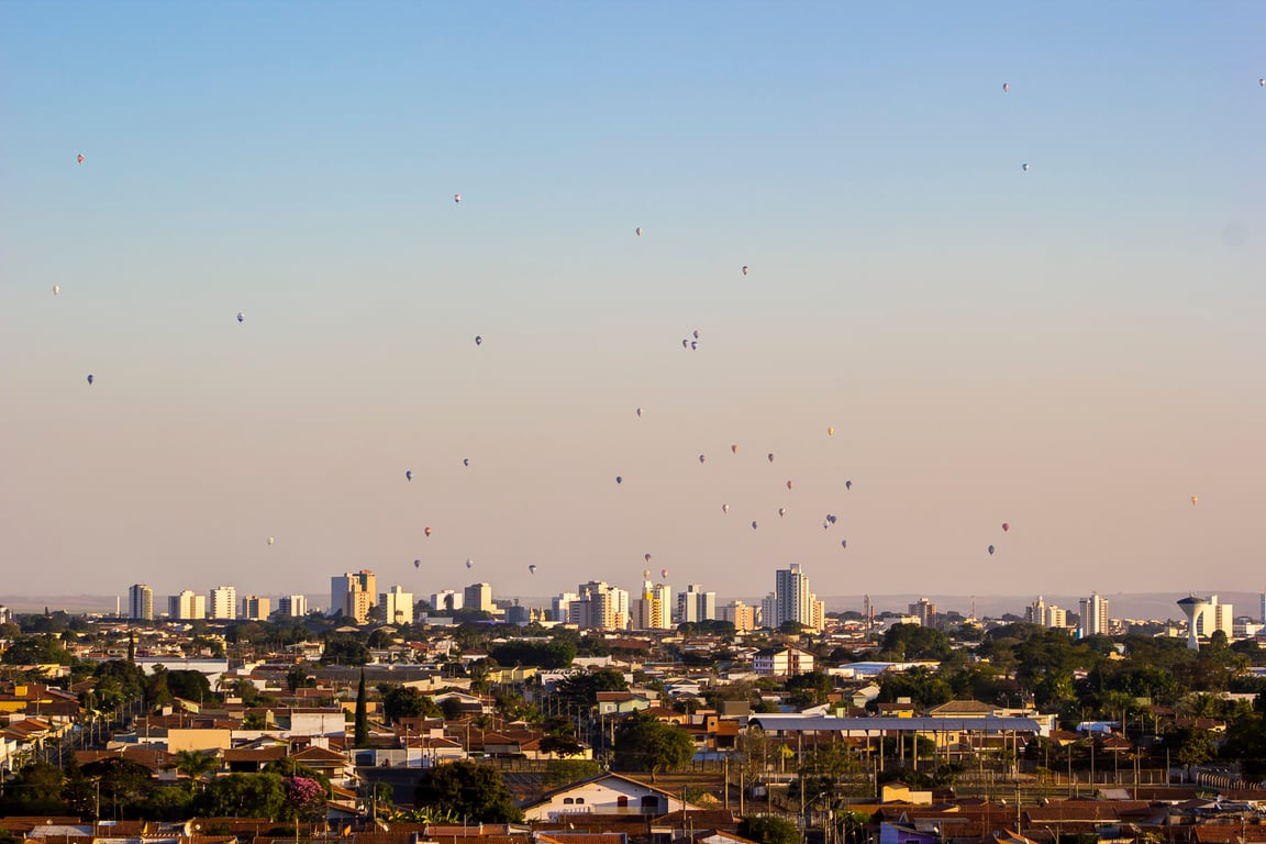 Vista aérea de Rio Claro SP, com balões no céu e paisagem urbana ao fundo