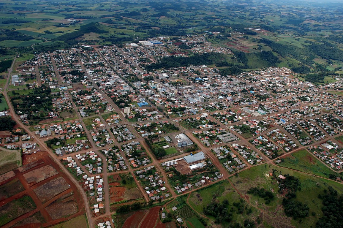 Vista aérea de cidade do Oeste Catarinense com ruas arborizadas e prédios baixos.