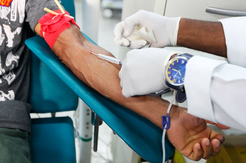 Profissional de saúde acompanha doação de sangue em ambiente hospitalar