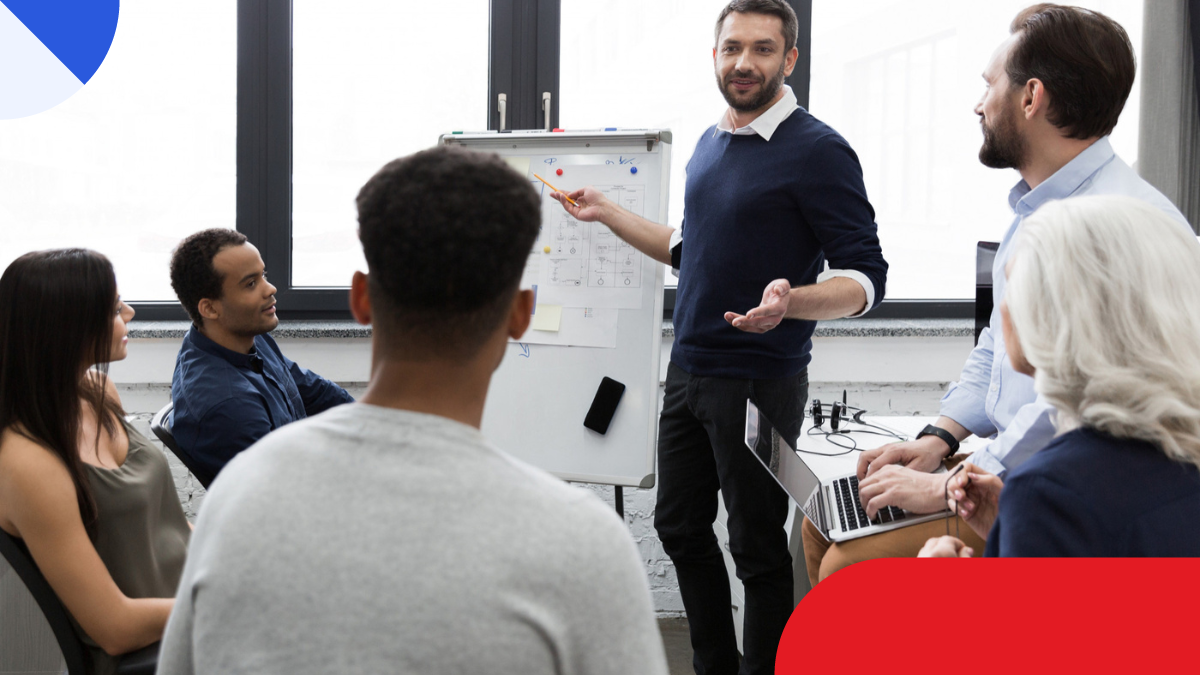 Reunião de equipe em ambiente de comunicação corporativa, com apresentação em lousa e notebook