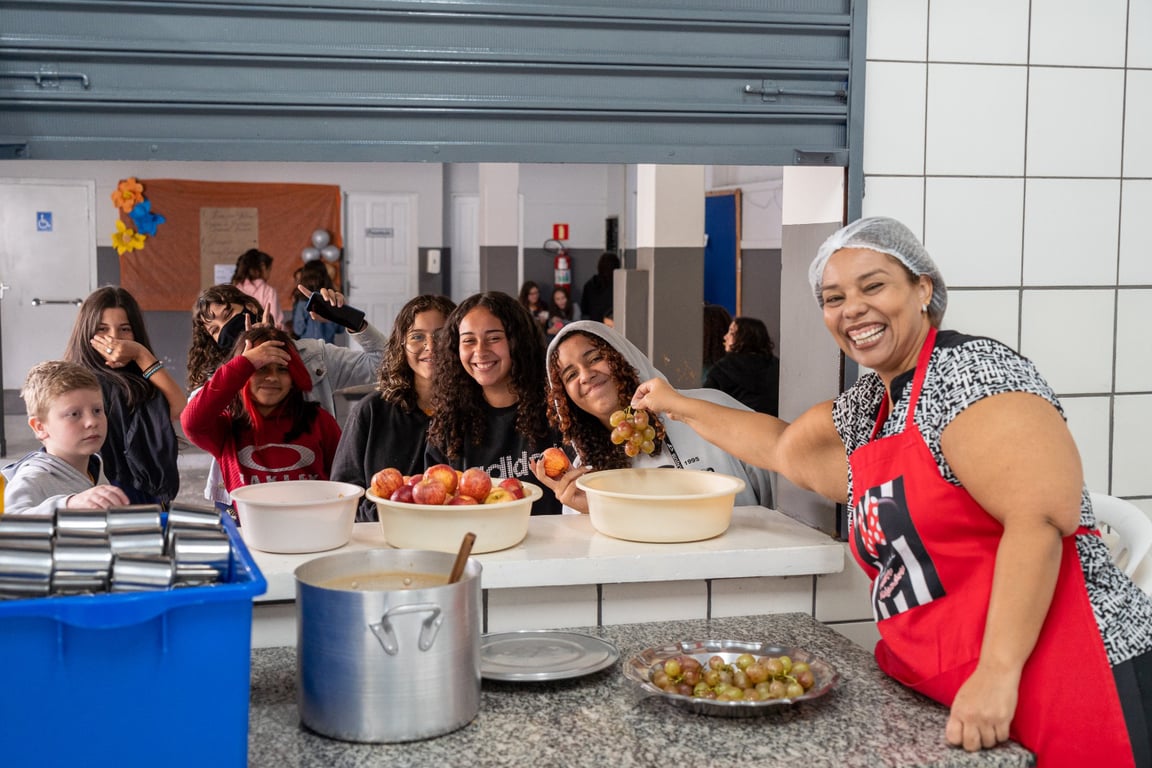 Merendeira preparando frutas em escola pública, ilustrando o cotidiano do cargo
