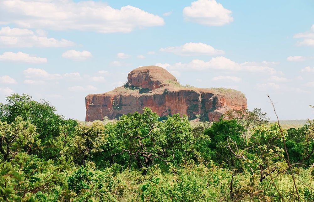 Paisagem do Cerrado goiano, com rochas e vegetação típica, em um dia de céu azul
