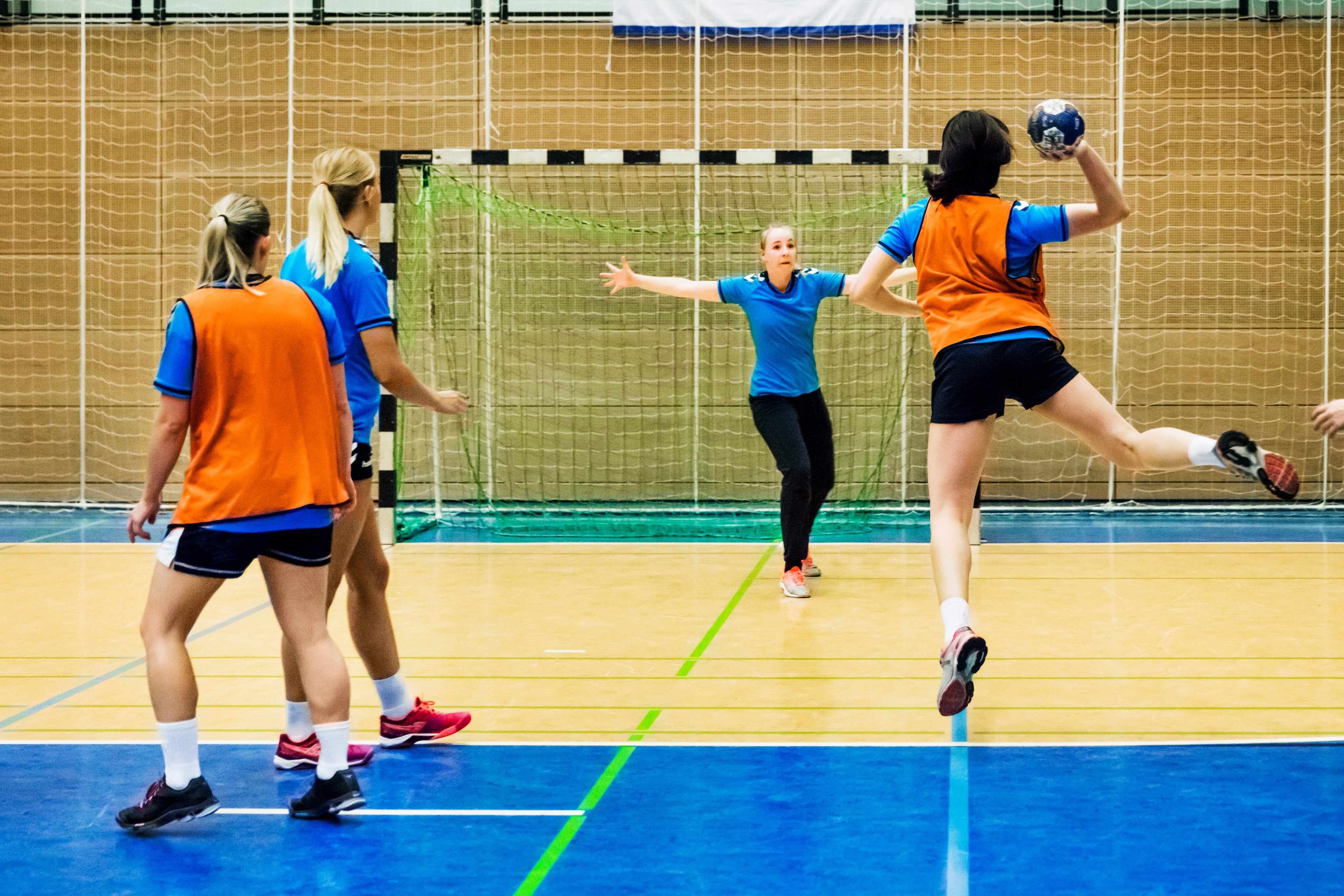 Quadra poliesportiva com estudantes em aula de handebol