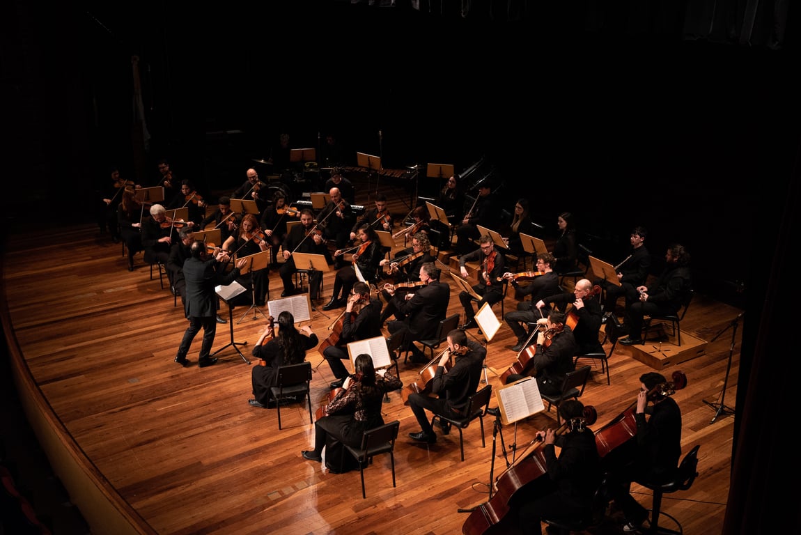 Ensaio orquestral com quarteto de cordas em sala de concerto, ambiente acadêmico