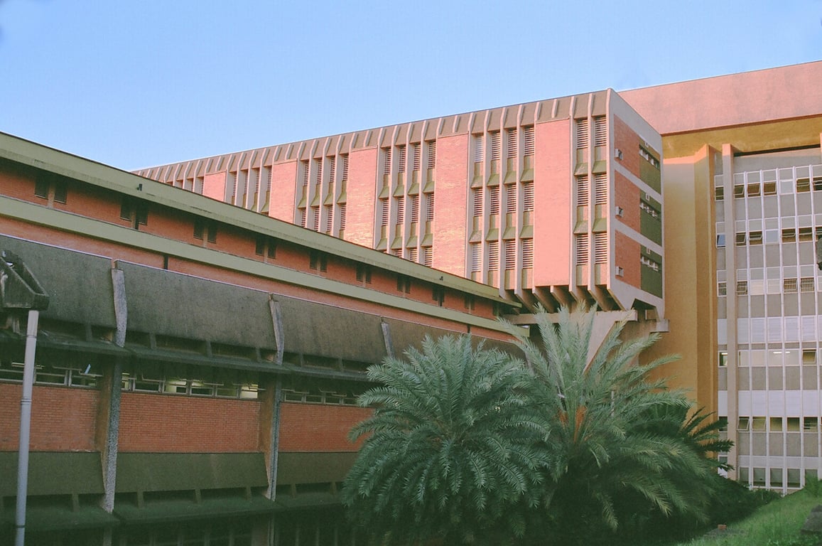 Campus da Unicamp ao entardecer, com prédios e áreas verdes