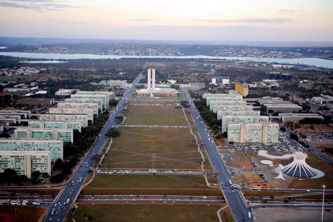 Vista aérea da Esplanada dos Ministérios em Brasília, com o Congresso Nacional ao fundo, no fim de tarde