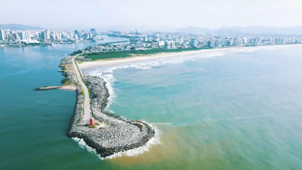 Vista aérea do litoral de Navegantes, Santa Catarina, mostrando praia e área urbana ao fundo