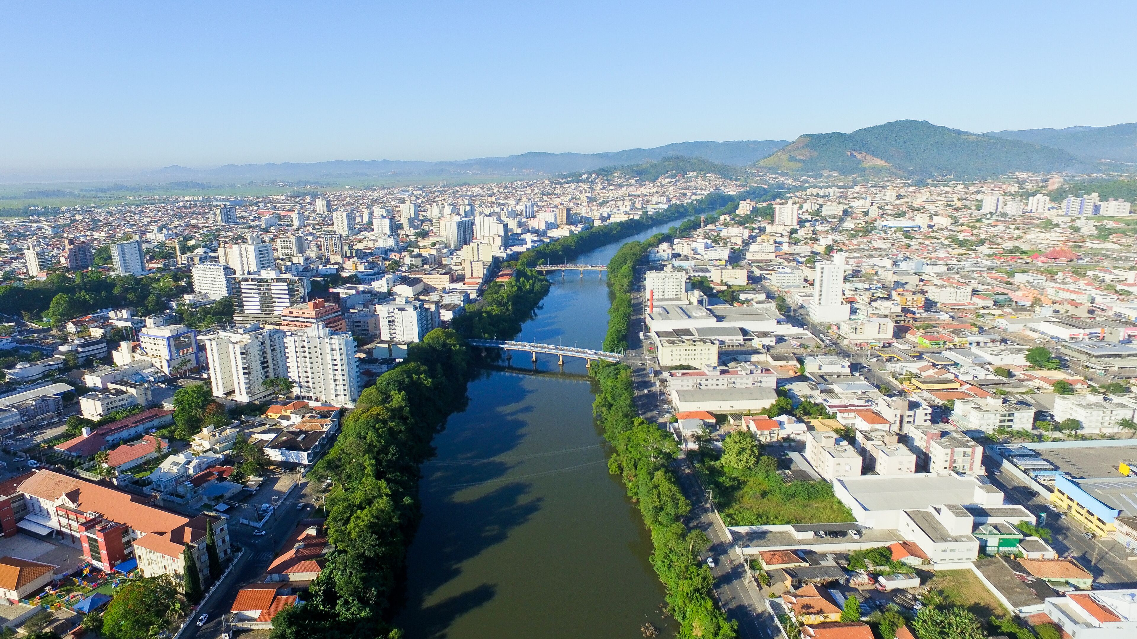 Vista aérea de Tubarão SC, com o rio Tubarão cruzando a cidade em dia claro