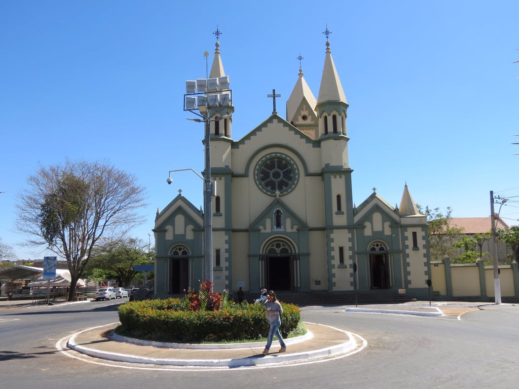 Centro urbano de Curvelo MG, com igreja e vegetação, em dia de movimento