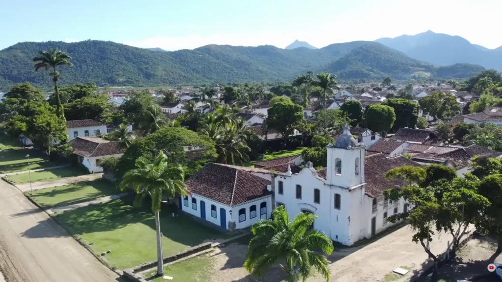 Praça com igreja e casas coloridas no interior do Maranhão ao entardecer