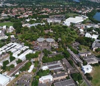 Vista aérea do campus da Unicamp em Campinas ao entardecer com prédios e áreas verdes