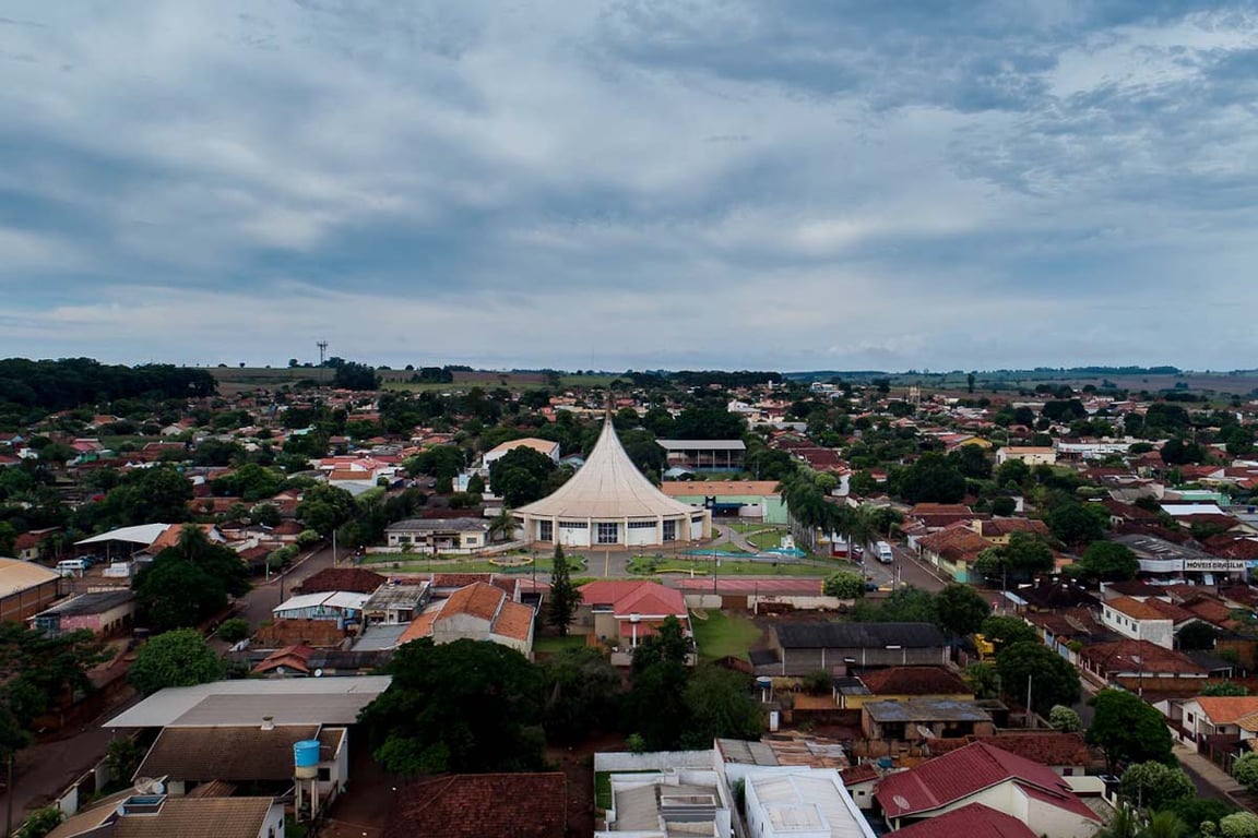 Vista aérea de Vicentina (MS), com área urbana, casas e áreas verdes em dia ensolarado