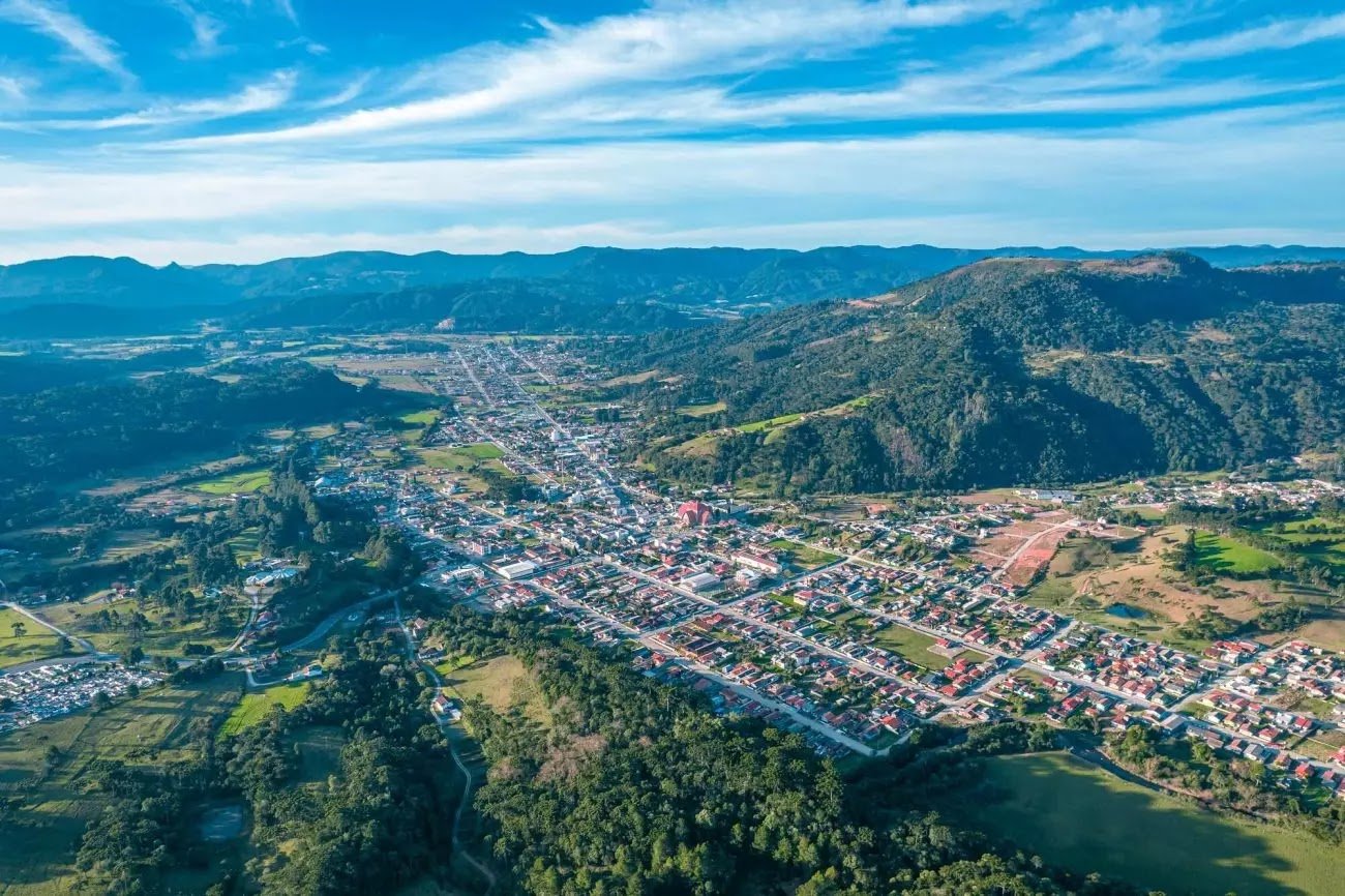 Vista aérea de cidade do Meio-Oeste catarinense, com áreas verdes e baixa verticalização