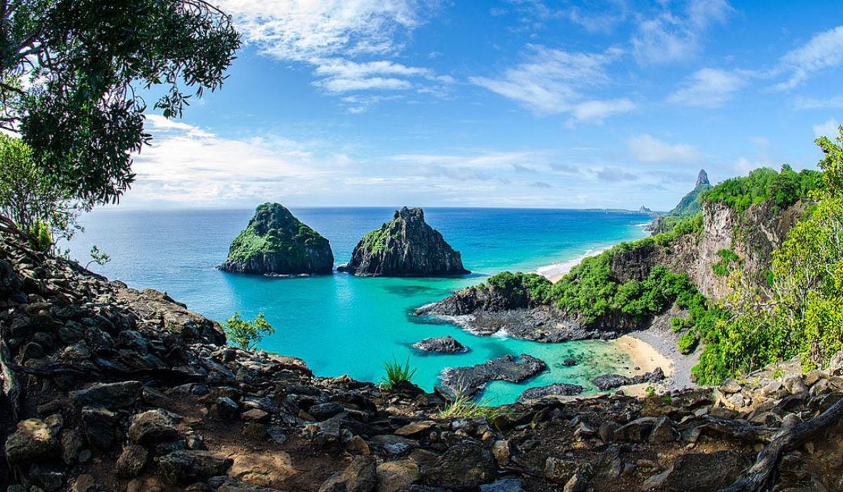 Paisagem de Fernando de Noronha com falésias e mar azul, vista ampla do Parque Nacional Marinho