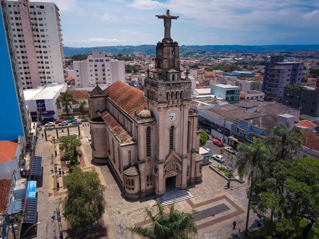 Vista urbana de São Tomás de Aquino MG, com igreja matriz e casario baixo sob céu azul