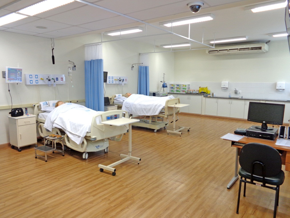 Ambiente de simulação em Enfermagem, com manequins e leitos em laboratório didático