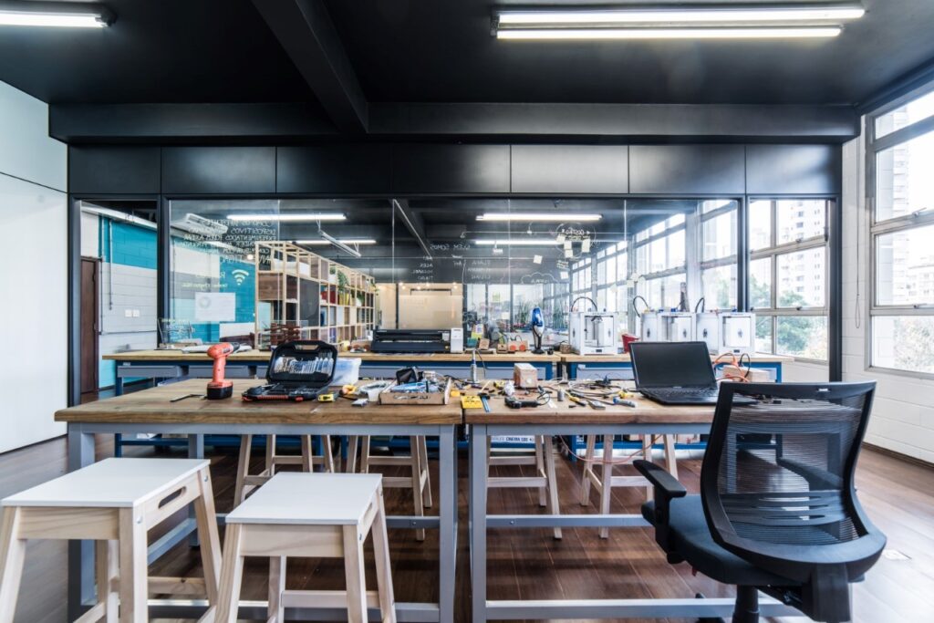 Ambiente de laboratório criativo, com mesas, equipamentos e iluminação natural, ideal para atividades de design