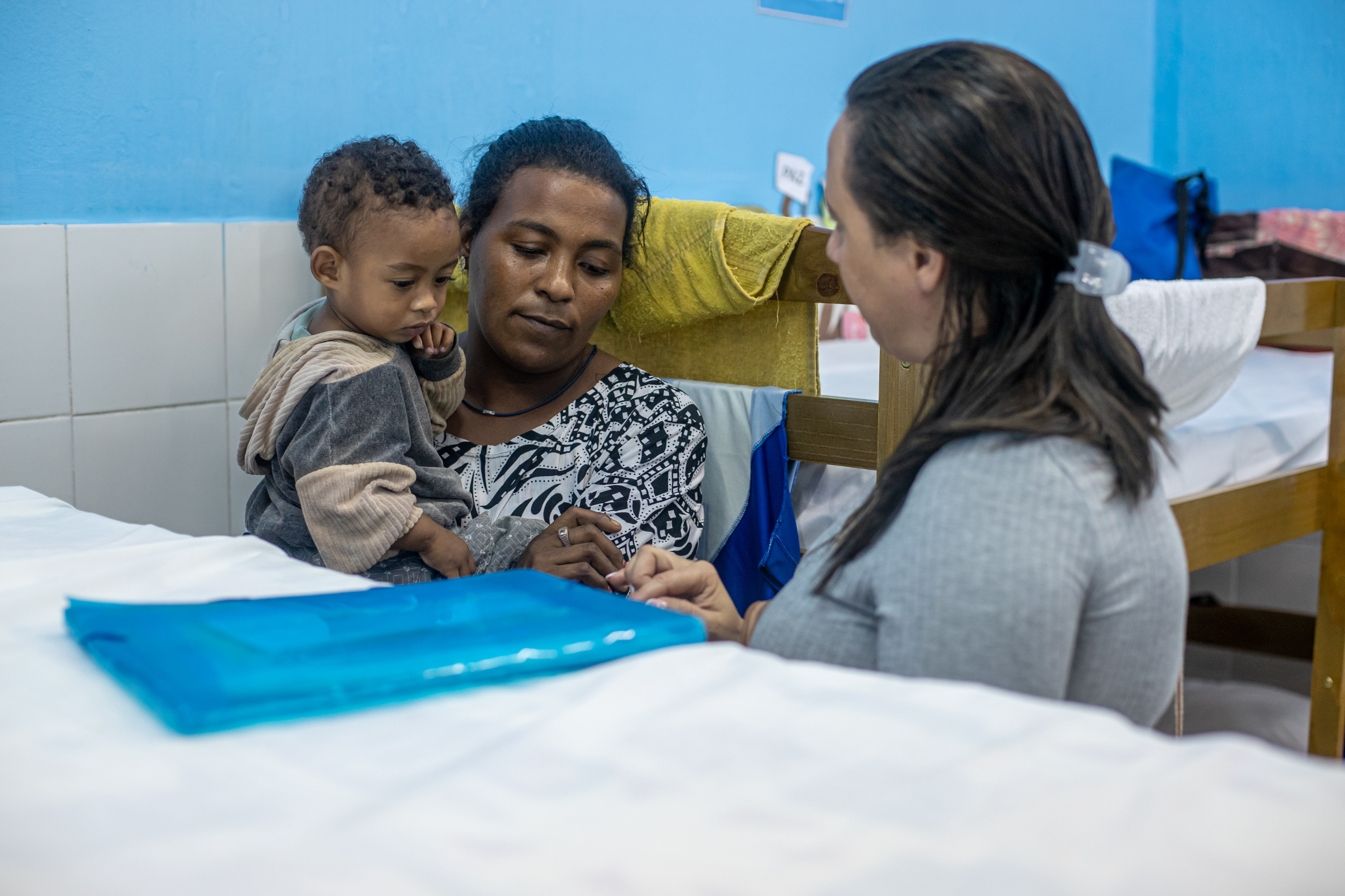 Profissional de assistência social organiza um ambiente acolhedor, sem identificação de rostos