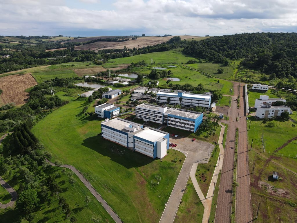 Vista aérea do campus da UFSM, com prédios acadêmicos e áreas verdes ao fundo