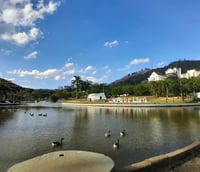 Paisagem urbana de Monte Sião, com praça, lago e vegetação ao redor