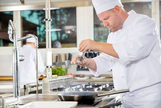 Cozinha industrial-escolar com equipe preparando refeições