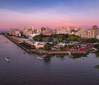 Orla do Guaíba ao pôr do sol com skyline de Porto Alegre ao fundo