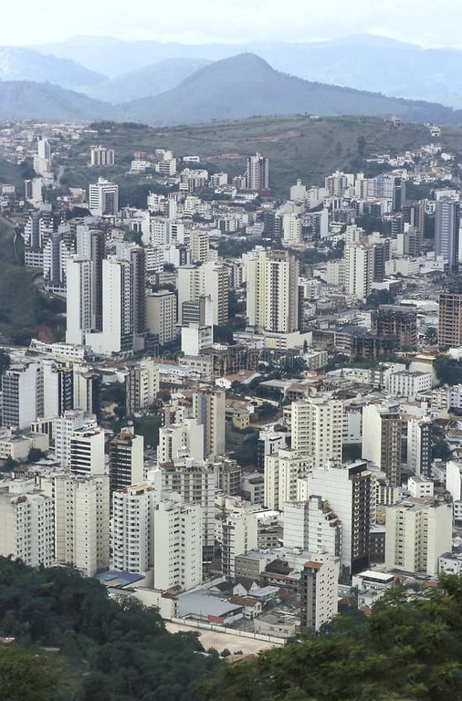 Vista panorâmica de Juiz de Fora com morros ao fundo, em dia claro