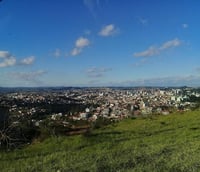 Vista aérea de Barbacena MG em região montanhosa.