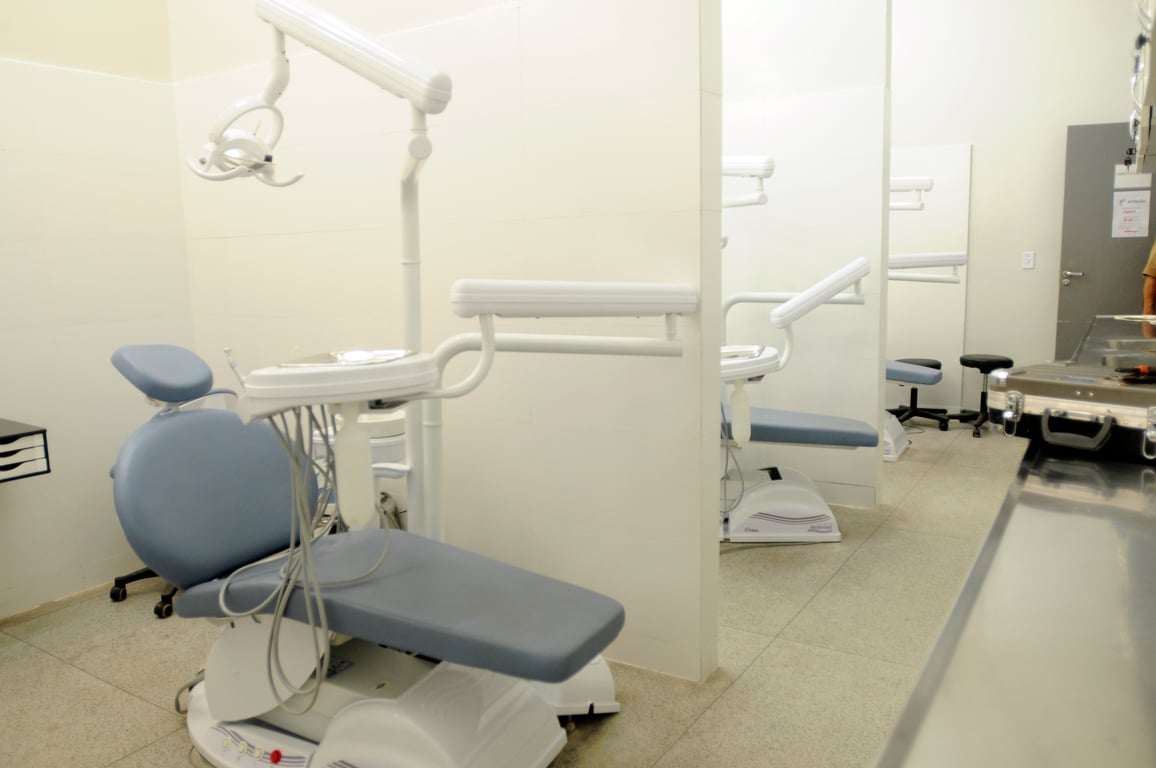 Consultório odontológico em Unidade Básica de Saúde do SUS, com cadeira odontológica e equipe de saúde bucal