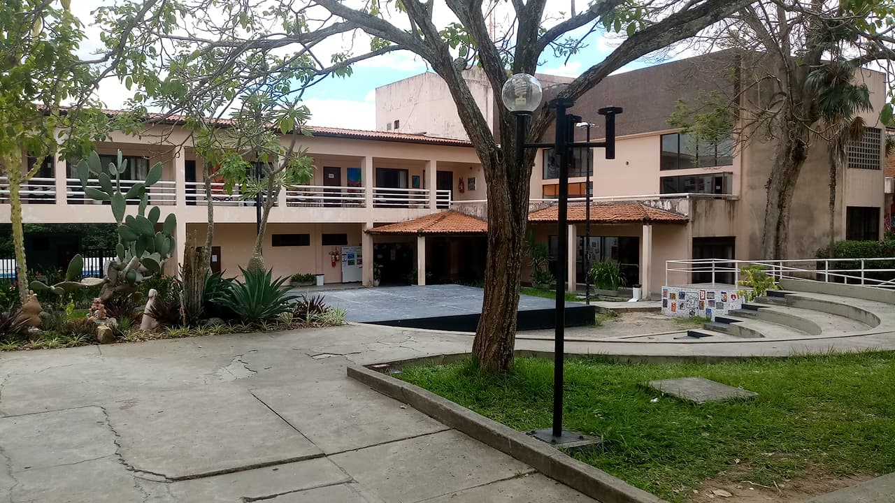 Campus universitário público com áreas verdes e prédios acadêmicos.