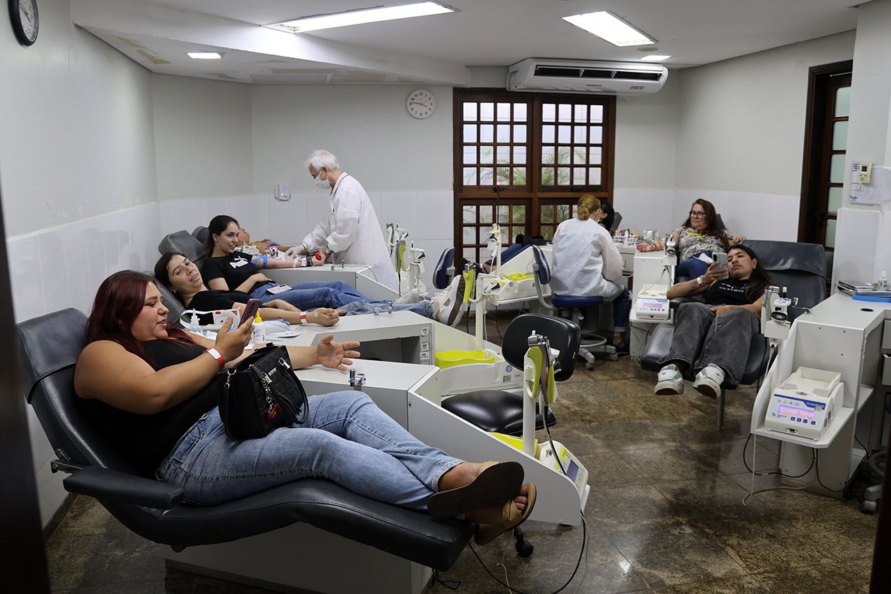 Profissionais de saúde acompanhando doação de sangue em ambiente de hemocentro