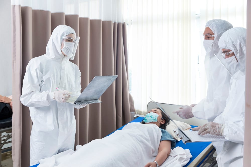 Equipe de enfermagem em hospital público brasileiro, usando EPI e crachás, em ambiente clínico luminoso