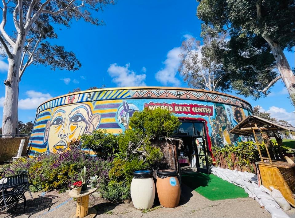 Fachada de um campus educacional em dia ensolarado, com áreas verdes e calçadas de circulação