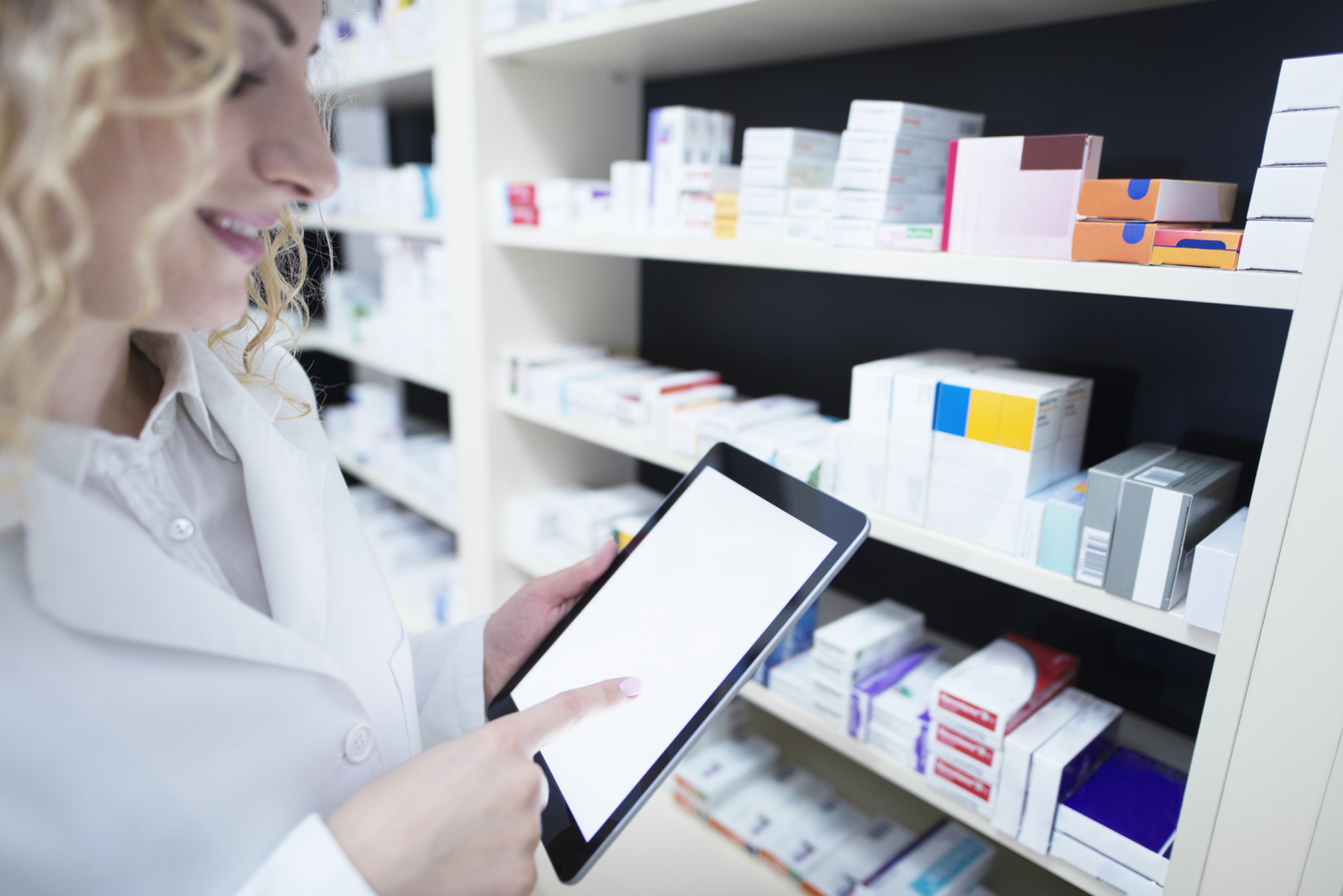 Profissional farmacêutica em ambiente hospitalar conferindo medicamentos