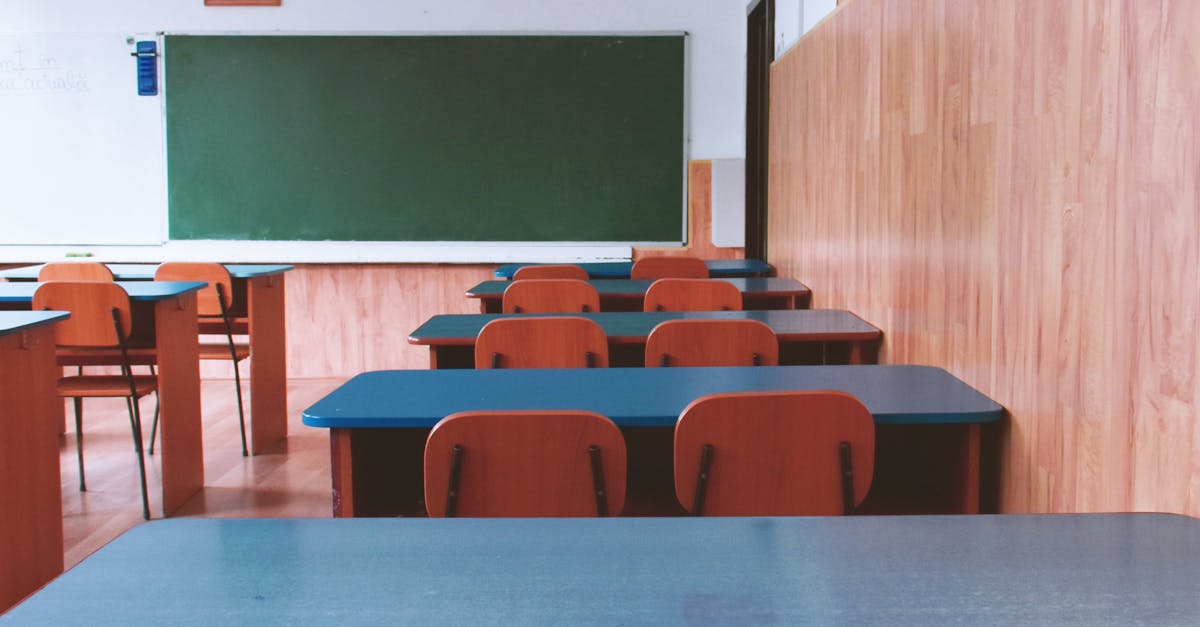 Sala de aula pública vazia com carteiras enfileiradas e quadro ao fundo