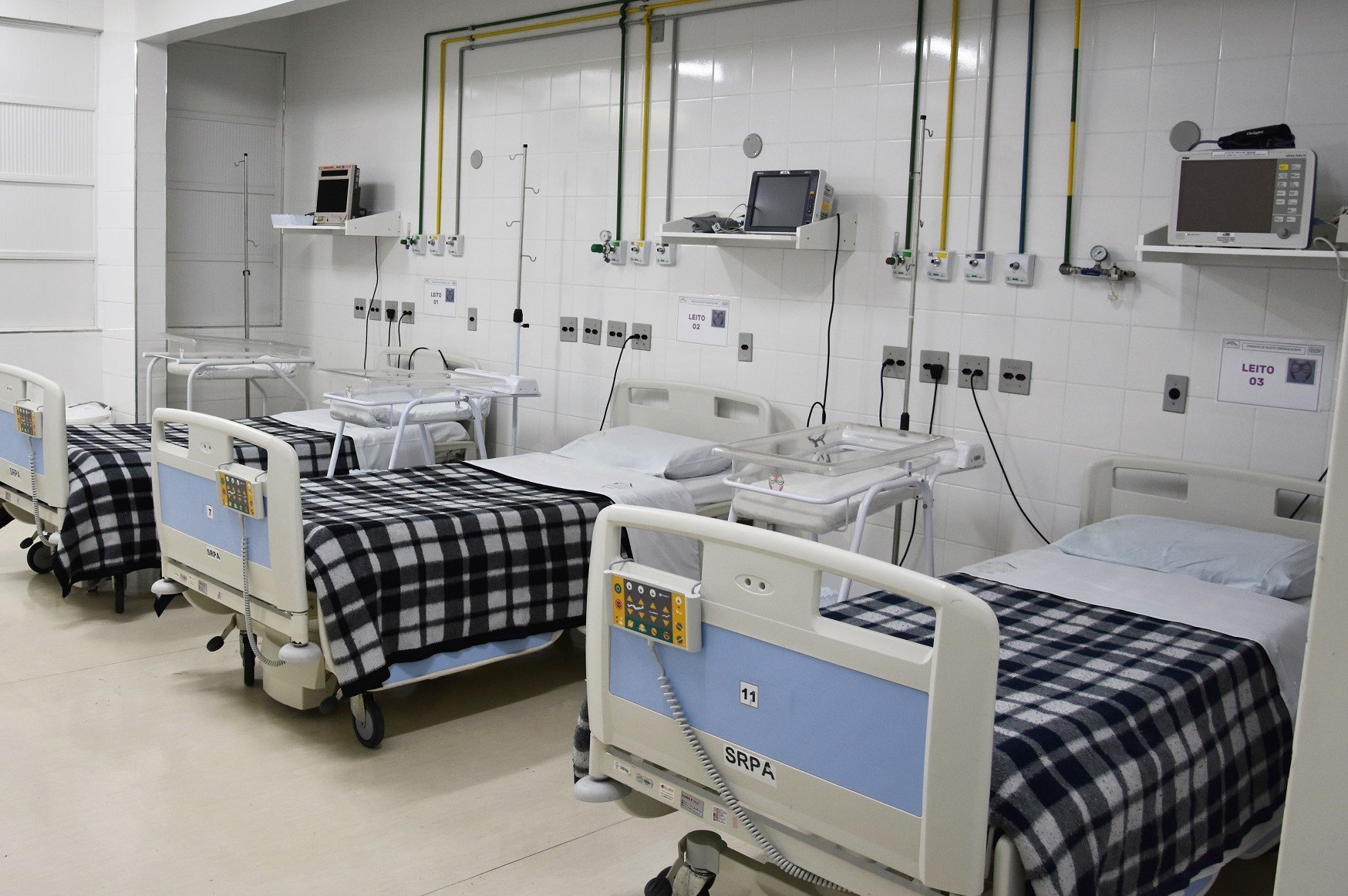 Ambiente hospitalar moderno e organizado, com leitos e monitores, ilustrando hospital universitário