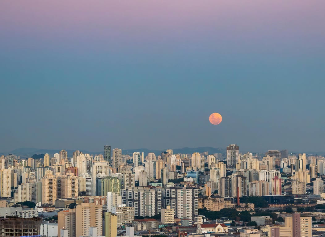 Horizonte urbano de São Paulo ao pôr do sol, com prédios iluminados