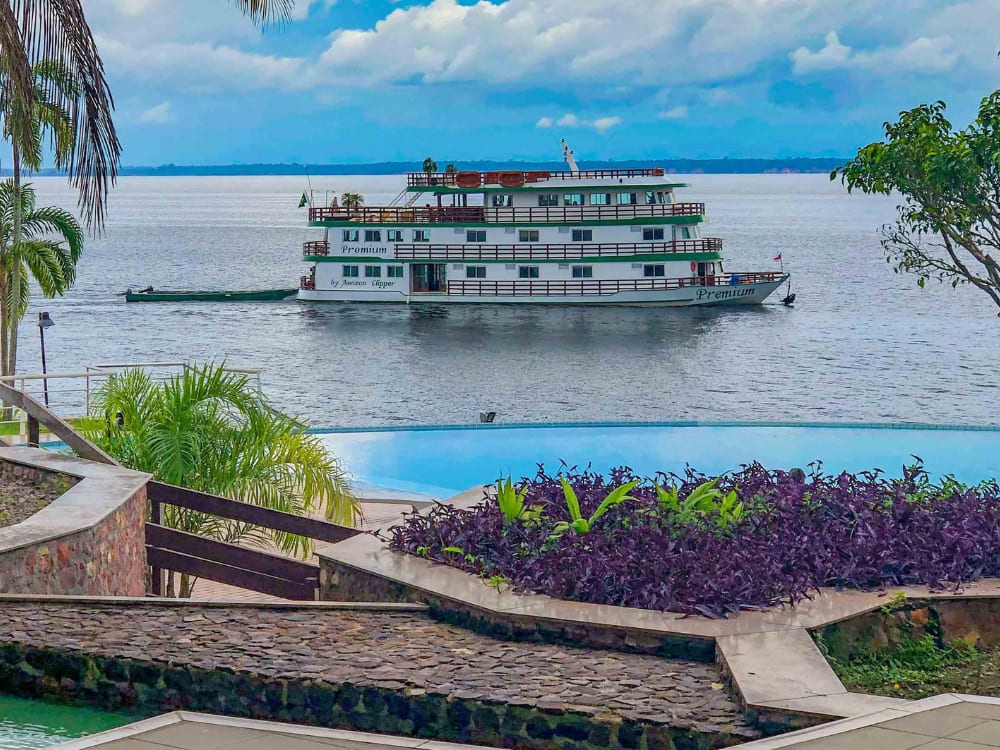 Barco de fiscalização em rio amazônico com vegetação densa ao fundo