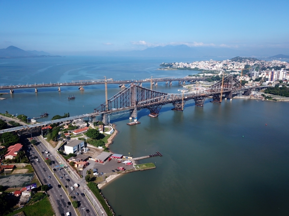 Vista aérea de Florianópolis com a Ponte Hercílio Luz ao entardecer