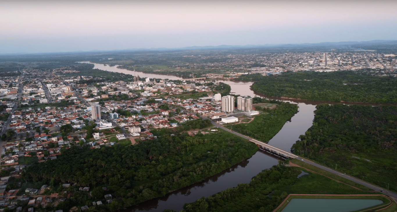 Paisagem urbana em Rondônia, com rio e floresta ao fundo