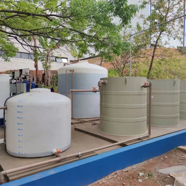 Estrutura de tanques e tubulações de uma estação de tratamento de água ao pôr do sol.