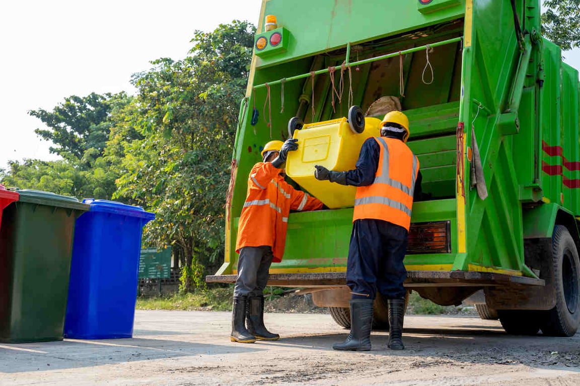 Caminhão de coleta urbana com equipe em operação