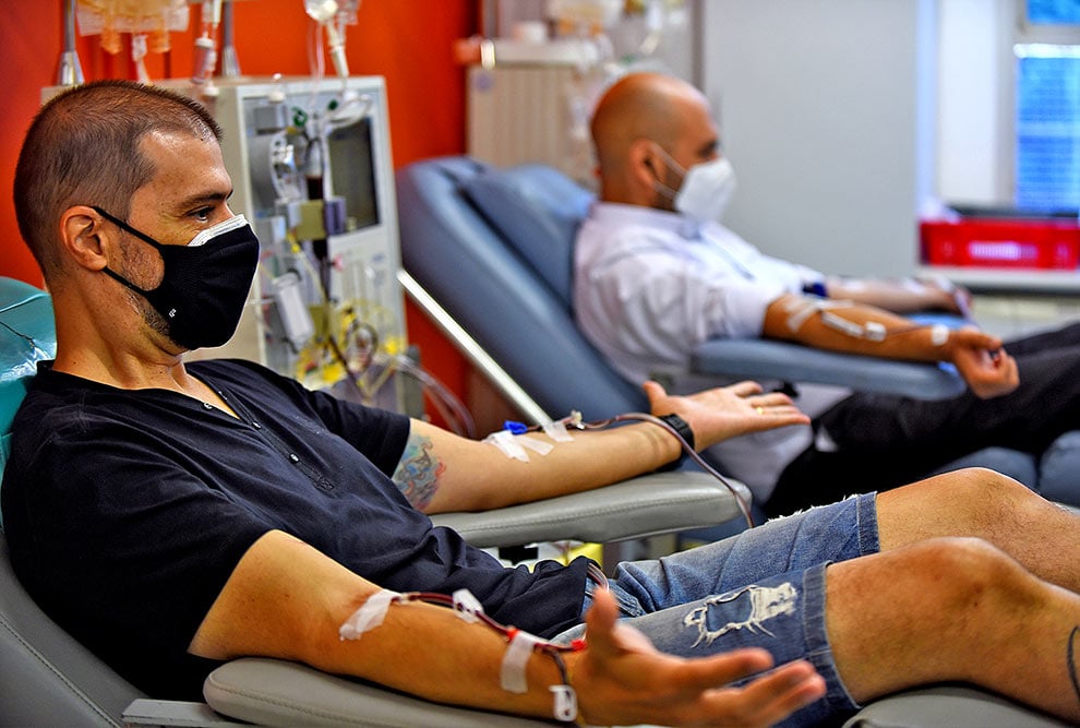 Ambiente de doação de sangue com cadeiras e equipe organizando equipamentos