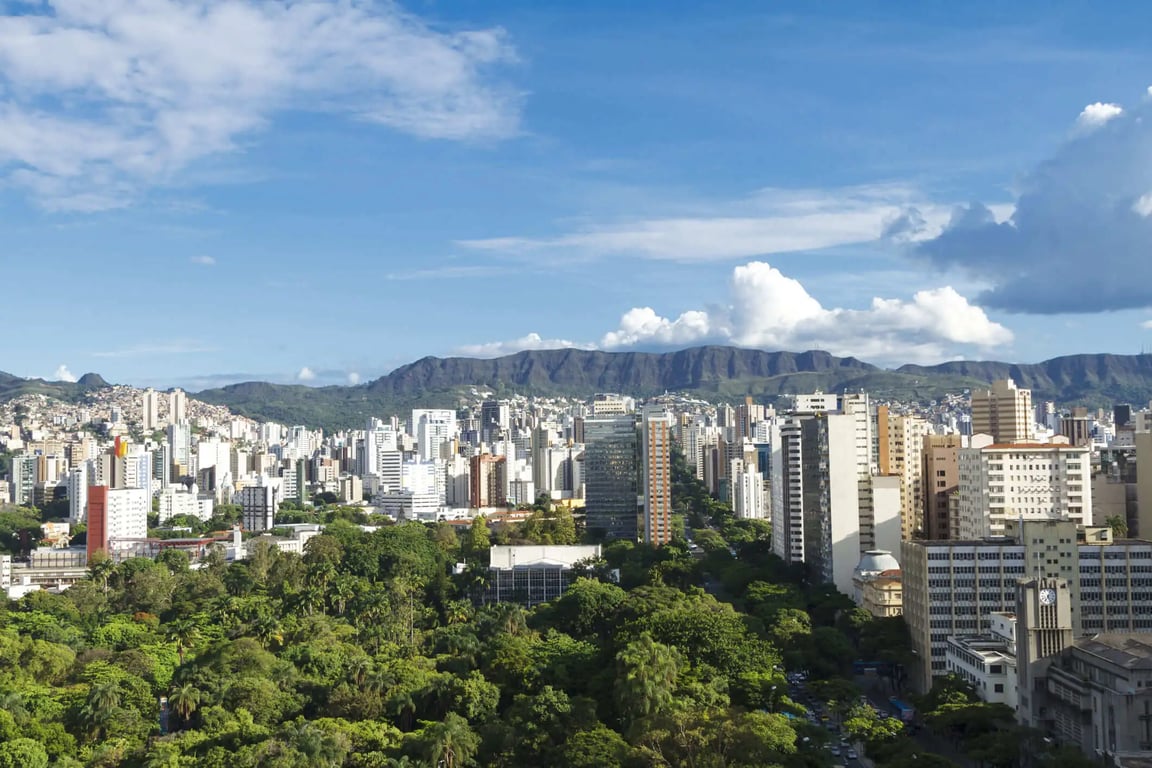Vista urbana de cidade do interior paulista, com praça arborizada e céu azul