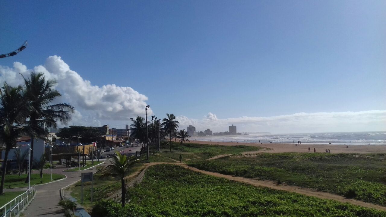 Vista aérea da orla de Jacaraípe, em Serra ES, com praia e área urbana ao fundo.
